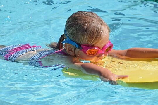 Little girl with diving goggles, swimming at Pareus Beach Resort