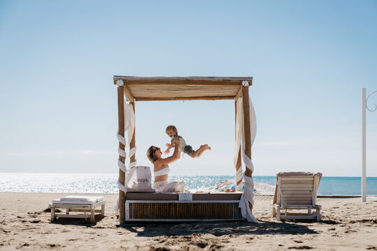 Mama und Kind in einer Strand-Cabana
