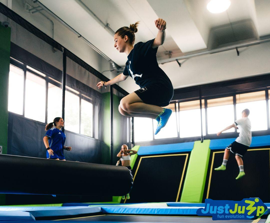 Trampoline hall with four children jumping. Two in the air and two standing. Jumping fun in Caorle