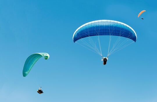 Two parachutists. One in the background and the other a little further forward.