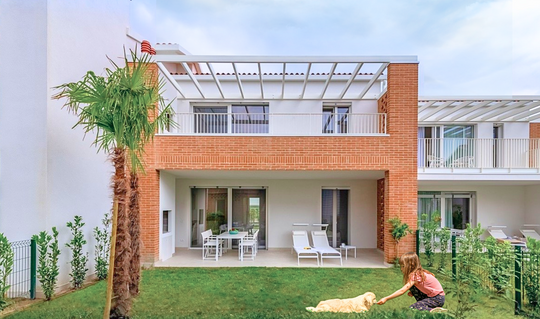 Child and dog playing in the garden of Suite Giardino at Pareus Beach Resort – relaxing family holiday in a lush setting.