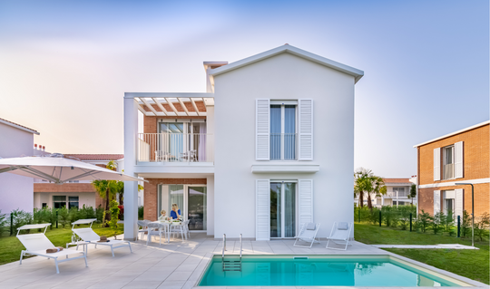 Mom and child enjoying the sunny terrace of Villa Mare at Pareus Beach Resort – relaxing family holiday by the sea.
